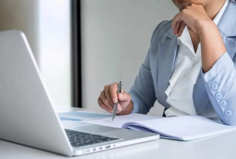 Businesswoman sitting at laptop trying to comply with Making Tax Digital