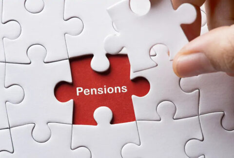 Hand holding last remaining jigsaw piece with the word 'Pensions' in the gap