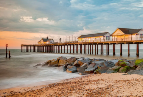 Three houses on pier at beach a sunset