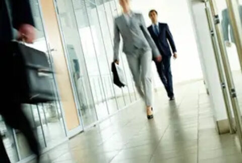 Two business people walking down an office corridor