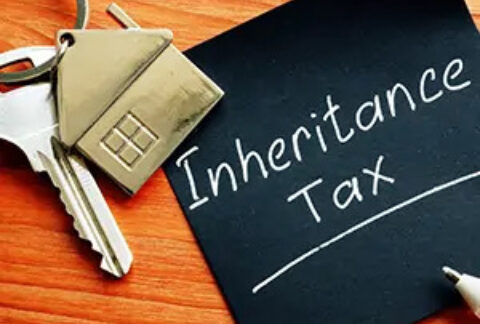 Post-it note with 'inheritance tax' written on it next to a key with a house keyring