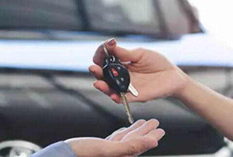 One person handing over a set of car keys to another