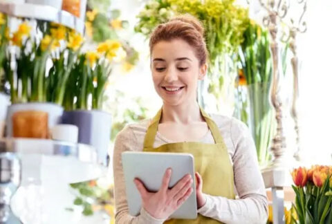 Woman working in florist shop using tablet