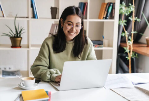 Woman working on laptop at desk at home