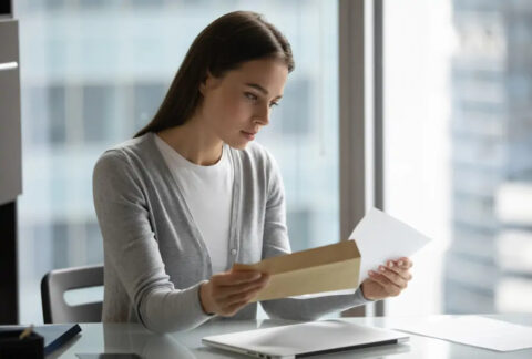 Businesswoman reading letter at desk
