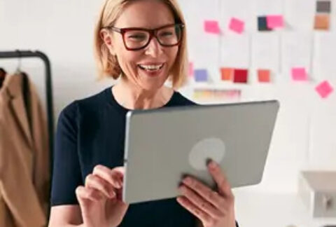 Businesswoman holding tablet and smiling at it