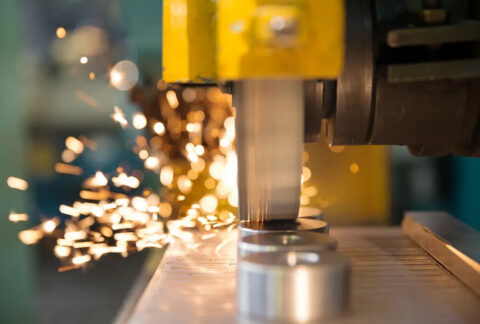 Close-up of metalwork machinery with sparks in background