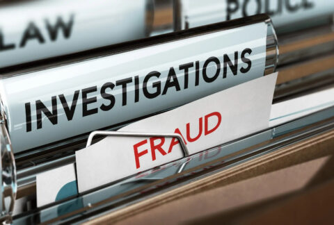 File folders with a tab labelled 'investigations' and the top of a document with the word 'fraud'